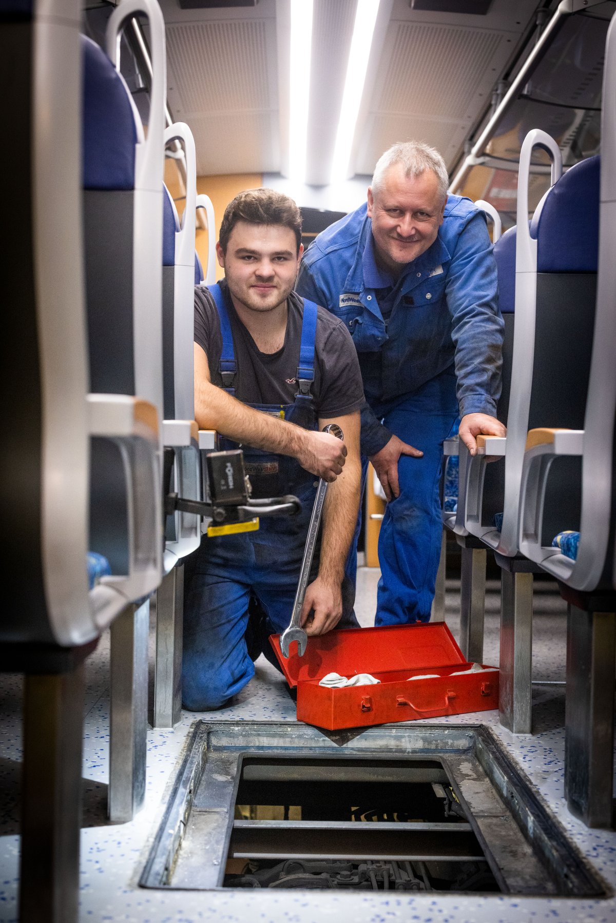 Auszubildender und Geselle bei der Arbeit in der Werkstatt.