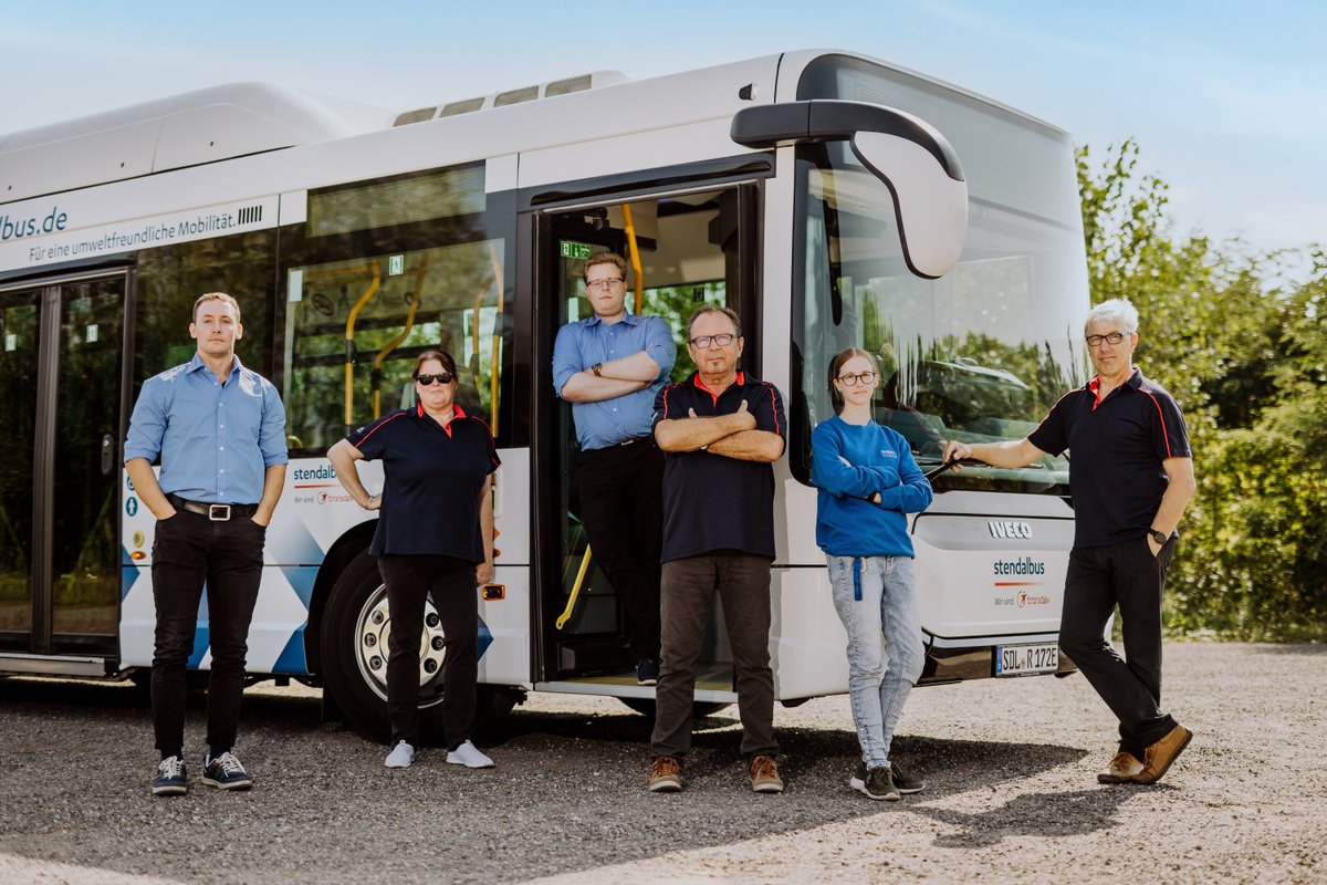 Gruppe posiert vor Bus 