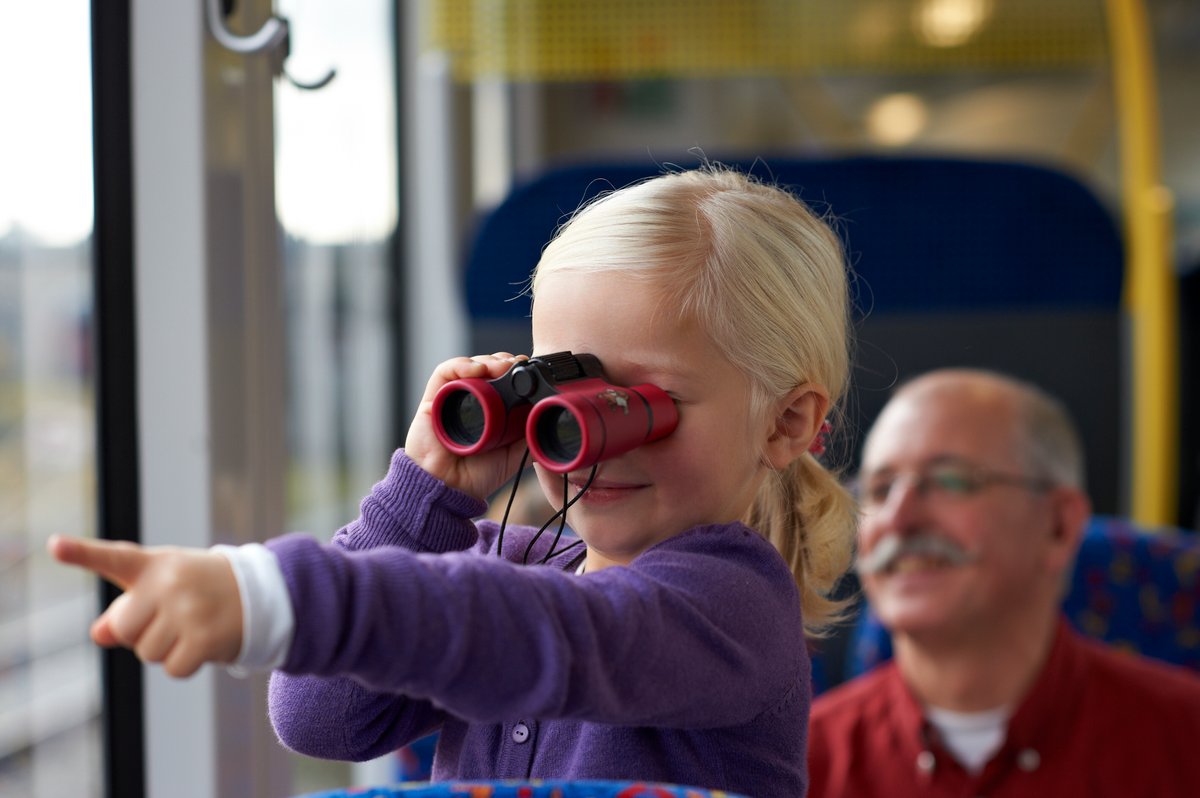 Kind mit Fernglas im Zug