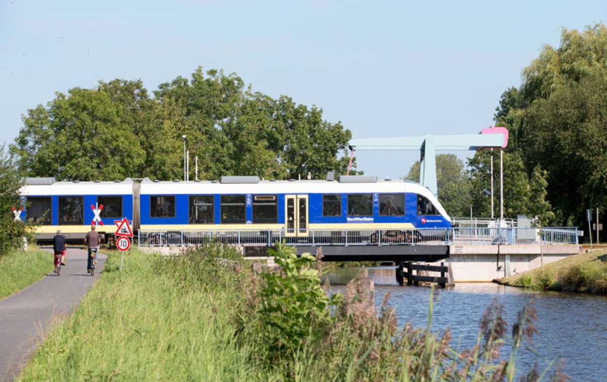 Museumsdorf Cloppenburg, Zug fährt über Kanalbrücke, Fahrradfahrer warten