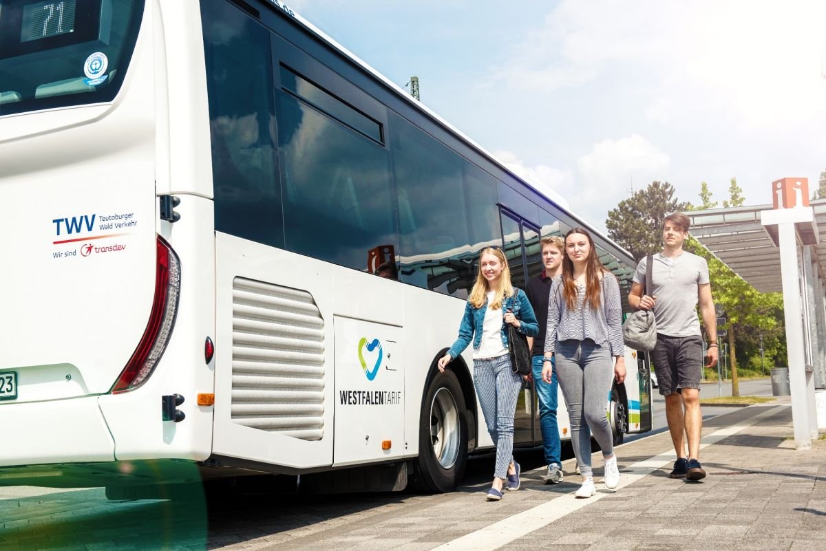Gruppe von jungen Leuten entfernen sich vom TWV-Bus. 